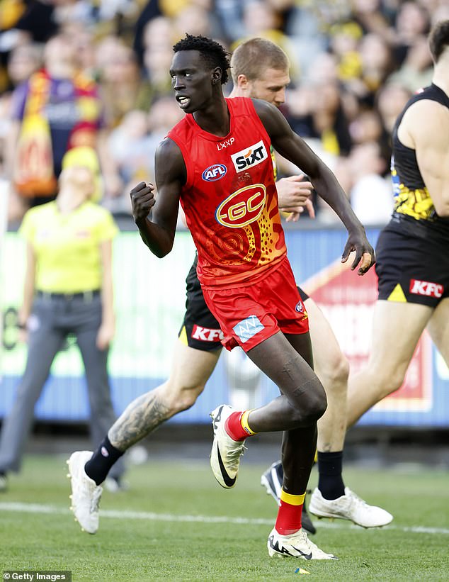 Gold Coast Suns star Mac Andrew is pictured wearing the club's Indigenous Round shirt with the old logo