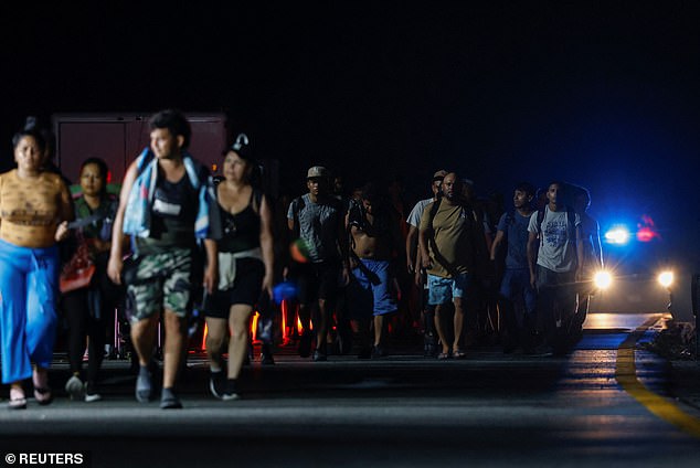 Migrants walk in a caravan along a highway on their way to the U.S. border, in Saltillito, Mexico, on November 7