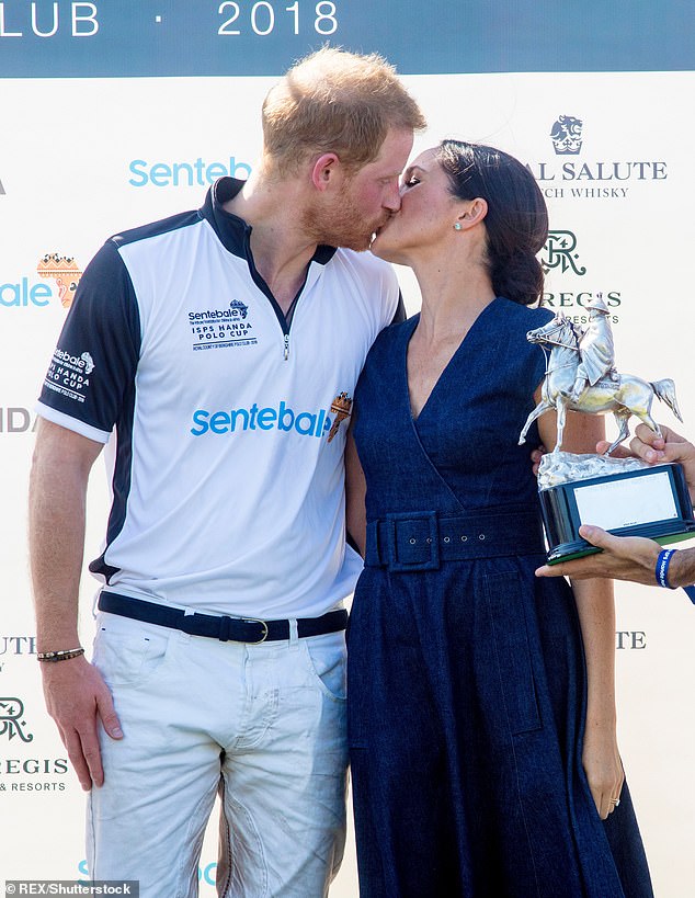 Harry and Meghan share a kiss after the prince won a charity competition in 2018