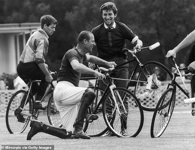 Prince Philip laughs after falling off his bicycle during a polo match in 1967