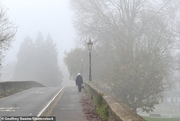 A pedestrian walks through foggy weather in Wallingford, Oxfordshire, last Thursday - an effect described by Bill Bryson as 'living in Tupperware'