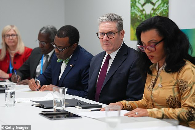 Keir Starmer, pictured holding a financial roundtable, emphasized that Britain can lead the way on climate change as he attended the COP29 summit today