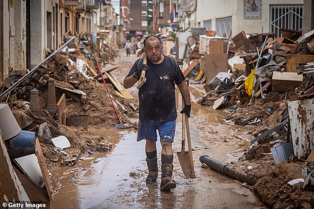 A man cleans his house after heavy rain and flooding hit large parts of the country on November 4, 2024 in Paiporta, Spain