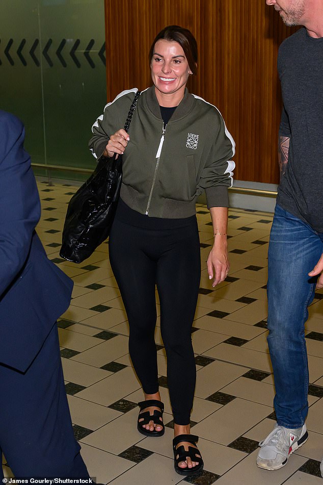 Coleen Rooney arrives at Brisbane Airport in Australia, carrying a £1,762 Chanel leather tote bag, a £1,000 Loewe nylon bomber jacket, with black leggings and Hermes gladiator sandals worth £730