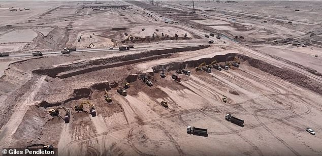 Diggers and trucks work on the foundations of The Line