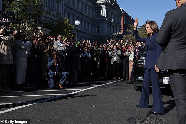 Vice President Kamala Harris waves to crowds of aides who greeted her return to the White House complex from the steps of the Eisenhower Executive Office Building on Tuesday