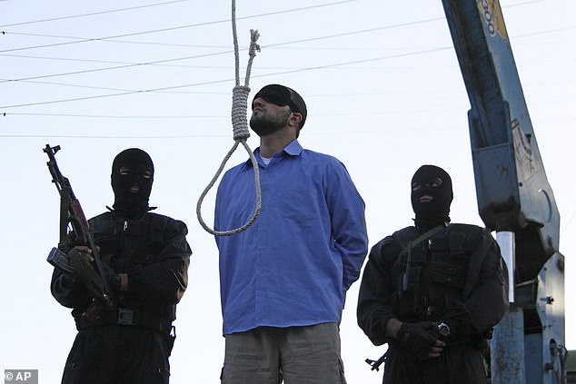 A blindfolded man convicted of armed robbery, kidnapping and murder of two police officers awaits public hanging in Tehran, Iran, on April 16, 2011.