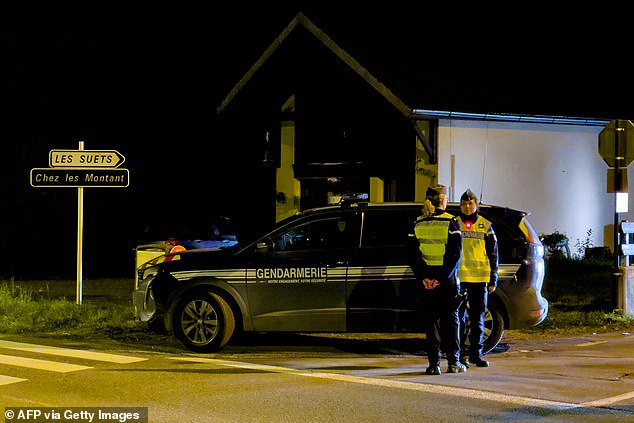 French gendarmes stand guard at the entrance to the street near the location where three children were found dead in Taninges on November 12, 2024