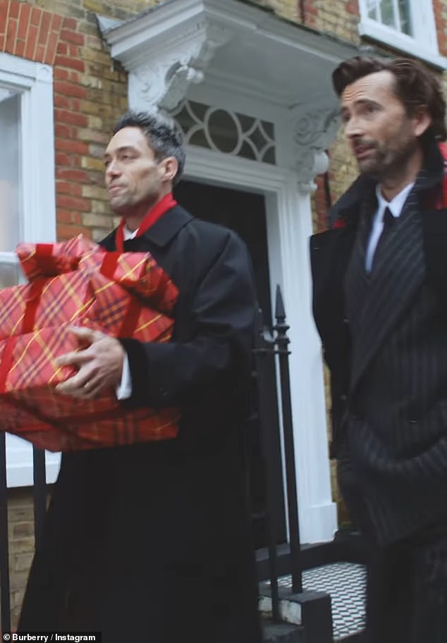 Meanwhile, Alex, 44, was seen in a similar suit, carrying a number of perfectly wrapped presents piled on top of each other in Burberry red wrapping paper.