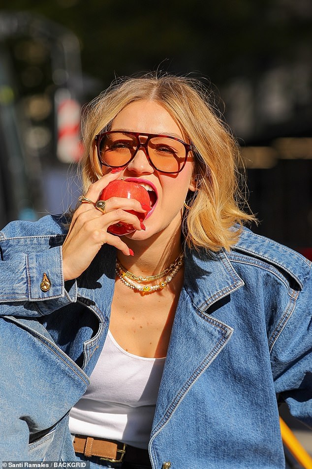 She also took a bite out of an apple in a cheeky reference to New York City, called on an old-fashioned, lip-shaped telephone and showed off her blood-red manicure.