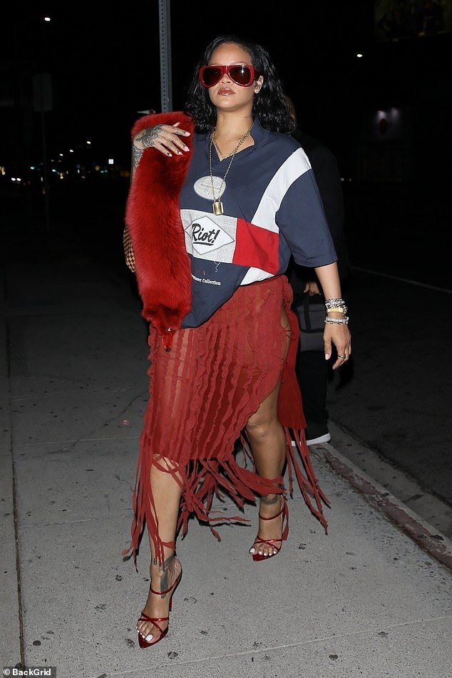 For a glamorous touch, Rihanna wore a red fur scarf over one shoulder and pranced down the sidewalk in sky-high heels