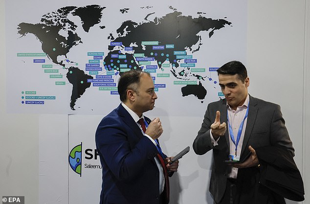 Participants talk while visiting an exhibition at the United Nations Climate Change Conference COP29 in Baku