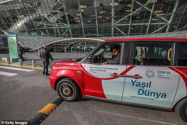 An electric taxi is parked in front of a terminal of Heydar Aliyev International Airport ahead of the COP29 United Nations Climate Change Conference on November 3