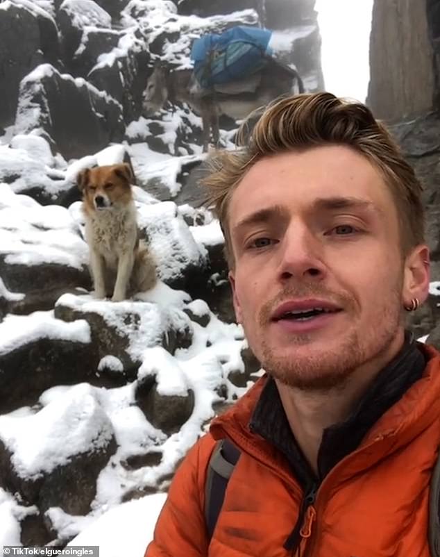 The hiker poses for a selfie with the dog that led him to the top of the mountain