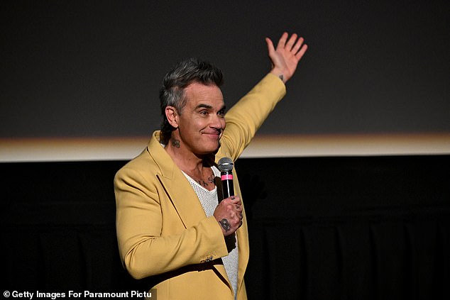 Robbie pulled up his long, graying locks as he beamed for photos before taking to the stage to talk to the audience