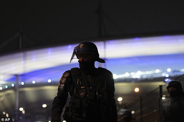 There is one police officer for every two football fans during Thursday night's match (photo: a riot police officer stands outside the Stade de France)