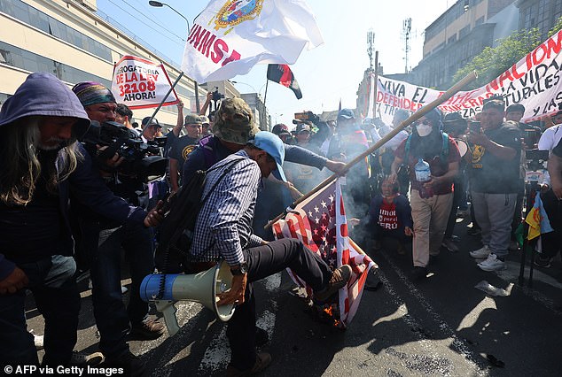 Protesters burn an American flag while participating in a protest against the Asia-Pacific Economic Cooperation (APEC) Summit in Lima on November 13, 2024