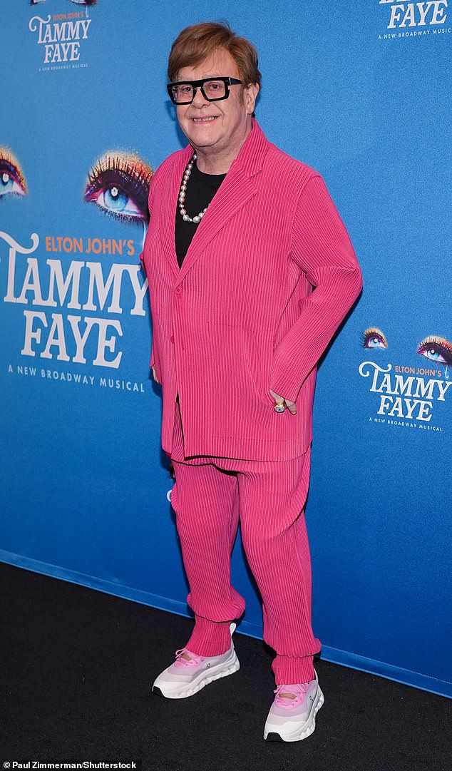 The Goodbye Yellow Brick Road music artist arrived in a pleated fuchsia two-piece with a shirt jacket and matching trousers