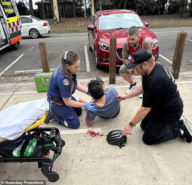 Pedro (top right) watches as paramedics help the man, who was bleeding after falling off his bike during the health emergency