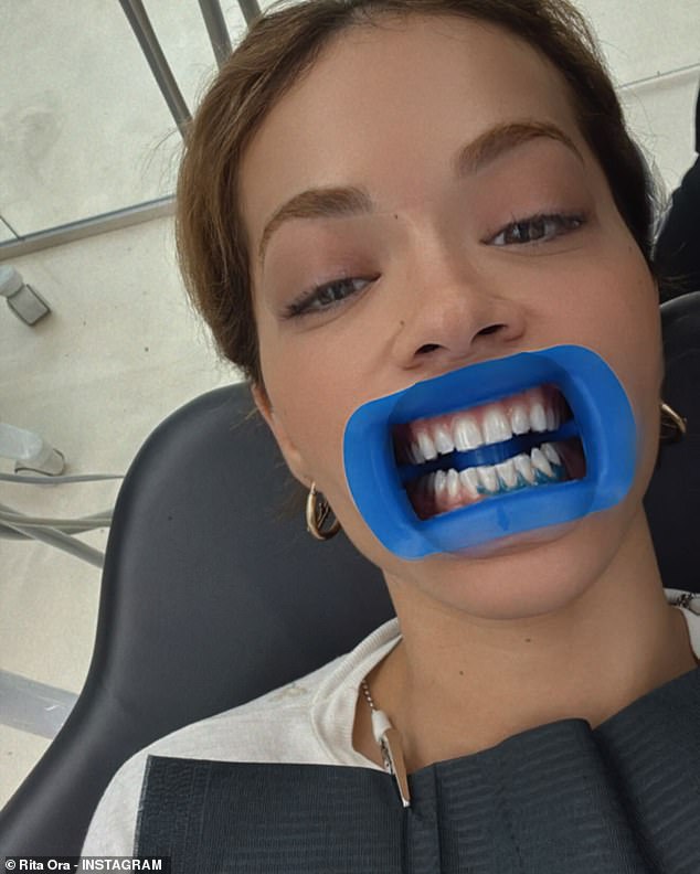 In stark contrast to the sizzling selfie, Rita then shared a photo of herself at the dentist with a mouth opener