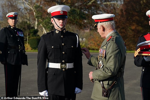 King Charles III, as Captain General of the Royal Marines, awards Marine Osian Stephens the King's Badge