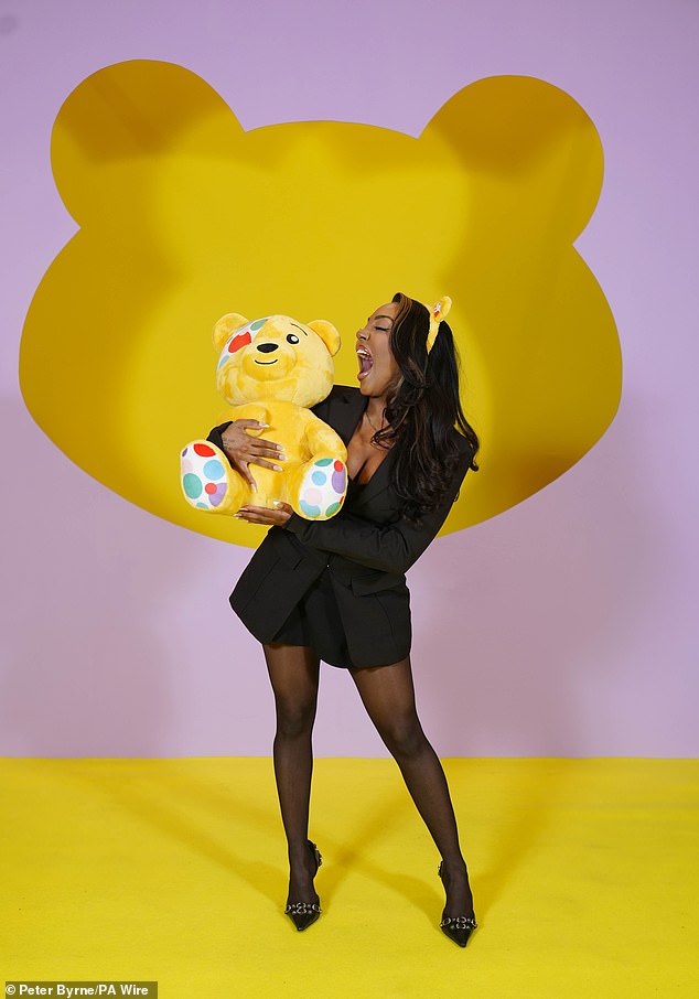 Influencer Ash Holme wowed in a plunging black blazer, tights and heels as she hugged Pudsey