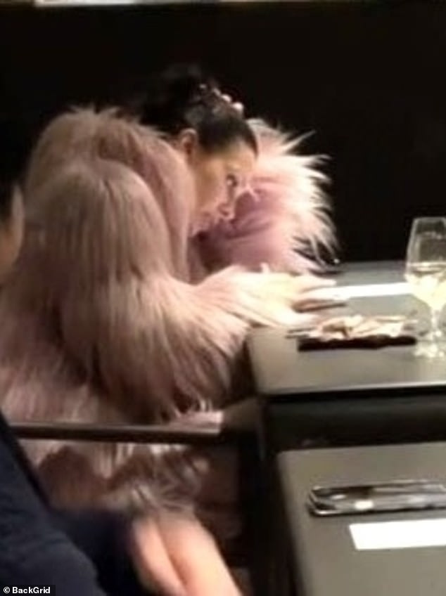 For once, Bianca - who appeared to be glued to her phone - donned a pink faux fur coat to combat Japan's rainy 46 degree Celsius weather