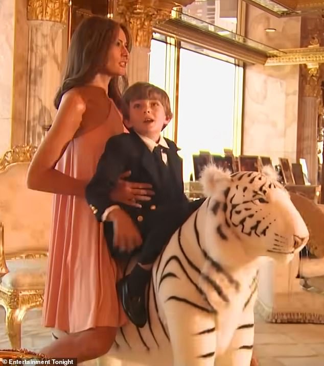 Melania and Barron pose together on a large stuffed white tiger as part of a photo shoot