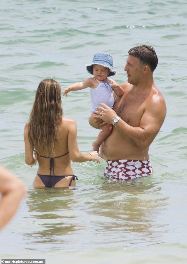 The one-year-old girl seemed to be having a great time at the beach, while mom and dad dutifully doted on her