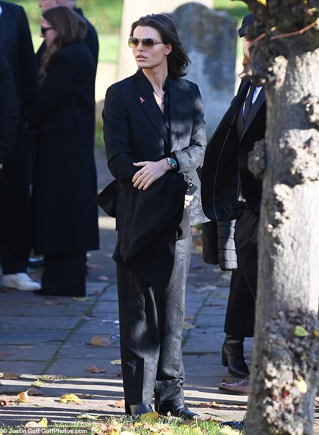 Damian Hurley waits outside with mourners for Payne's funeral