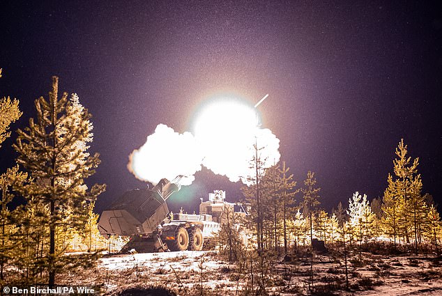 Snowflakes are illuminated during the live firing of the British Army's new Archer Mobile Howitzer gun near Rovaniemi in the Arctic Circle