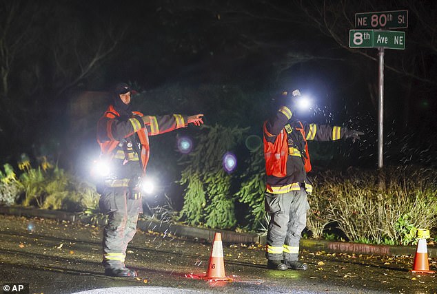 Seattle Fire Department personnel direct traffic from NE 80th St. after power lines fell across the street during the severe storm