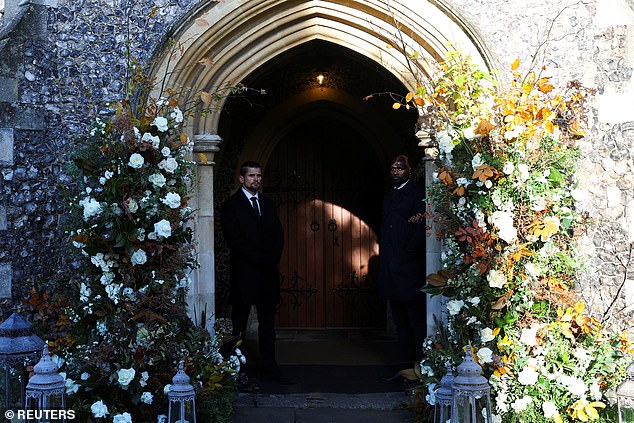 People stand in the door of a church before the funeral service