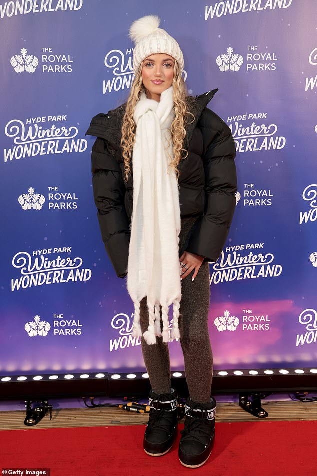 Princess wrapped warmly in a white pom-pom hat, matching scarf and padded coat