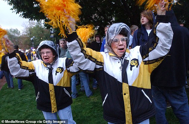 Twins Peggy Coppom (left) and Betty Hoover cheer on the Buffs years earlier