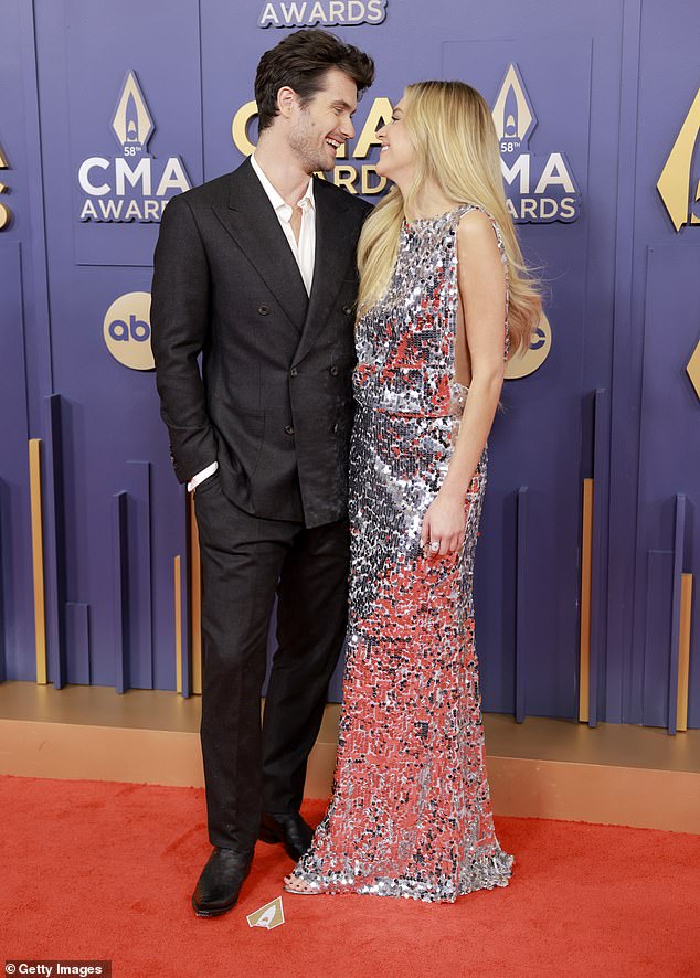 The 31-year-old country sensation and the 32-year-old Outer Banks star oozed elegance in their chic ensembles as they couldn't keep their hands off each other at the Bridgestone Arena in Nashville, Tennessee