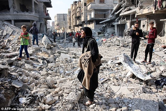 Palestinians walk amid the destruction after an Israeli attack in Jabalia in the northern Gaza Strip on November 10, 2024