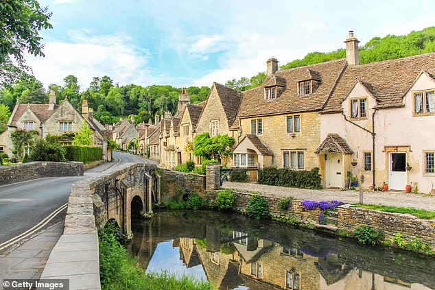 The TV presenter, 66, and her wife Portia de Rossi, 51, have moved to the Cotswolds, according to a new report in The Wrap; Pictured cottages at Castle Combe in Cotswolds, England