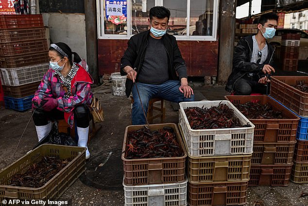 This photo taken on April 15, 2020, shows vendors wearing face masks as they offer shrimp for sale at the Wuhan Baishazhou Market in Wuhan, central China's Hubei province