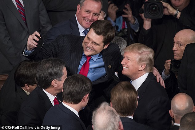 President Donald Trump takes a selfie with Rep. Matt Gaetz, R-Fla., in the House chamber after Trump's State of the Union address during a joint session of Congress on Jan. 30, 2018