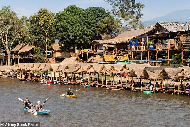 Tourists are pictured kayaking in Laos' party town of Vang Vieng, where six people have died from suspected methanol poisoning