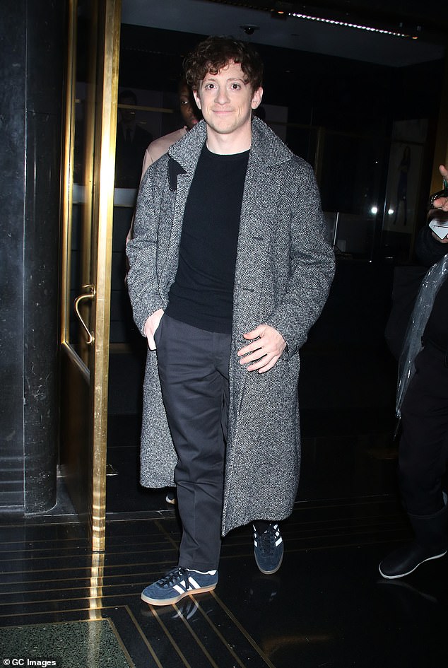 The 32-year-old looked casual in a gray overcoat, dark T-shirt and black trousers