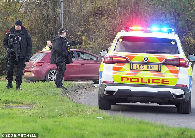 Armed police directed traffic at a roundabout near Gatwick Airport yesterday