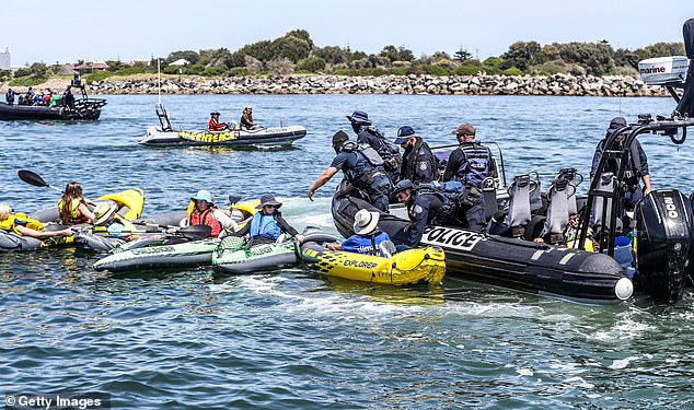 The climate protesters were arrested after failing to comply with a police directive to clear the shipping channel at Newcastle Harbor (photo police confronting protesters)