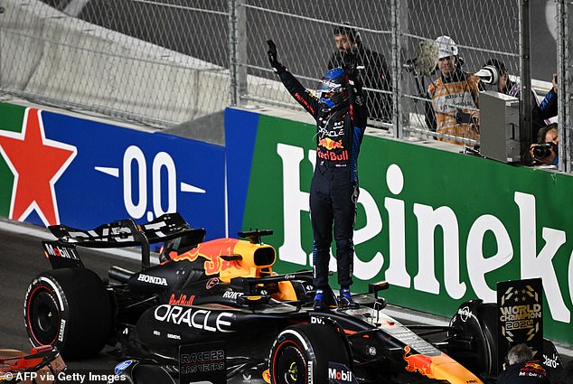 Verstappen stands atop his Red Bull machine after winning his fourth world title