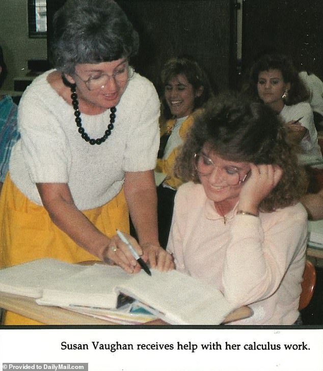 A smiling Smith is seen getting help from one of her teachers in math class. In the yearbook the caption reads: Susan Vaughan gets help with her math work.