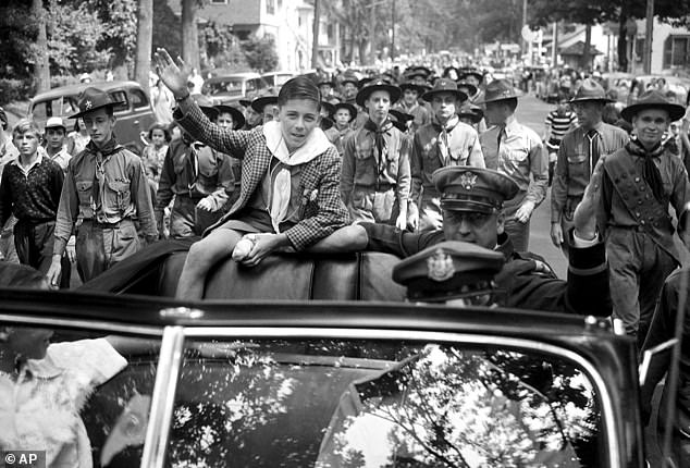 Donn Fendler, 12, his feet still bandaged from his days alone in the woods, waves as he is honored in his hometown of Rye, New York.