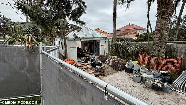 The roof and windows have been demolished, while roof tiles and building materials have been piled up at the back of the building