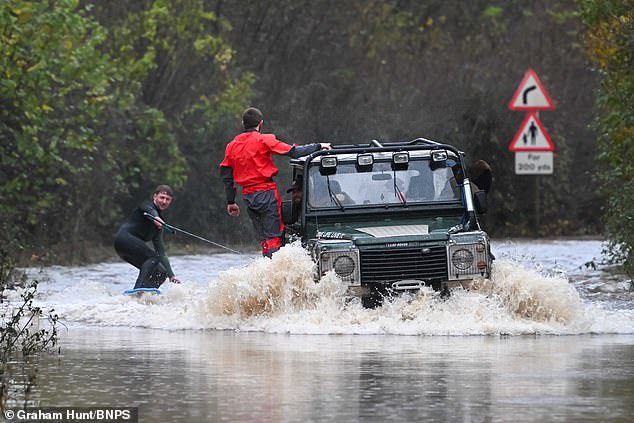 Young farmers with a 4x4 on Clay Lane at Chudleigh Knighton near Newton Abbot in Devon make the most of the flooding from Storm Bert by water skiing along the sunken road