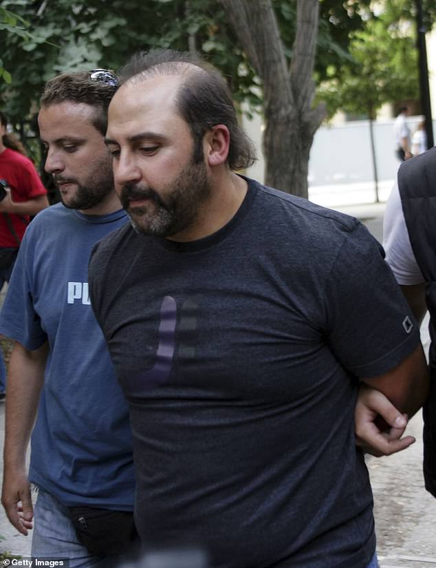 Mokbel is escorted by police officers after appearing in court on June 8, 2007 in Athens, Greece. He had fled Australia after being tipped off that he was about to be charged with murder